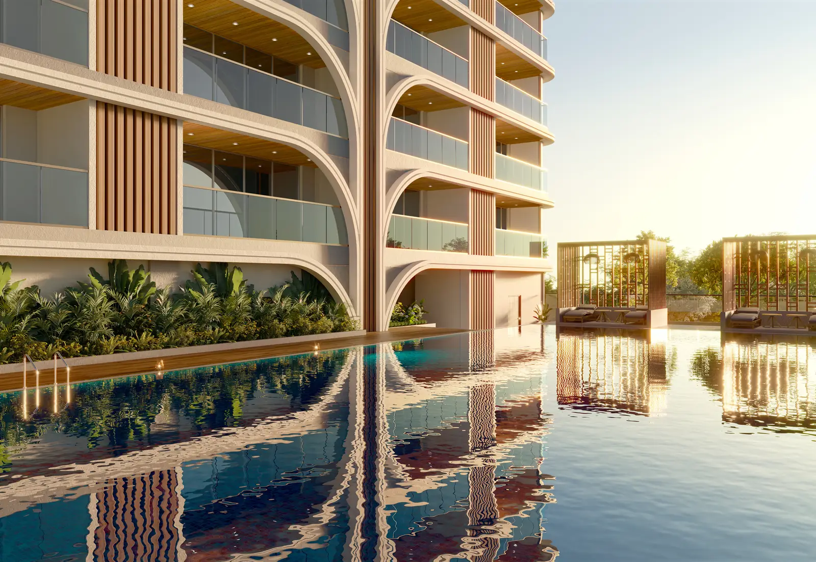 The pool deck at Sai Palm View, the tower's curved balconies mirrored in the water
